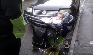 A baby in a pushchair, forced onto the road
