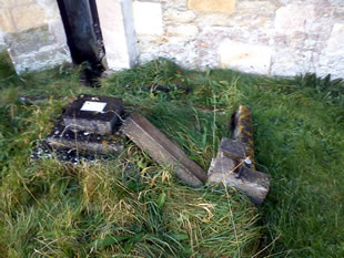Broken stone cross in Templecombe church graveyard, resulting from theft of roof lead