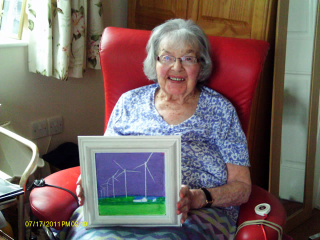 Joy Barnes, holding an example of her artwork