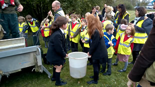 Girls from King Arthur's school carry the bucket to the river bank