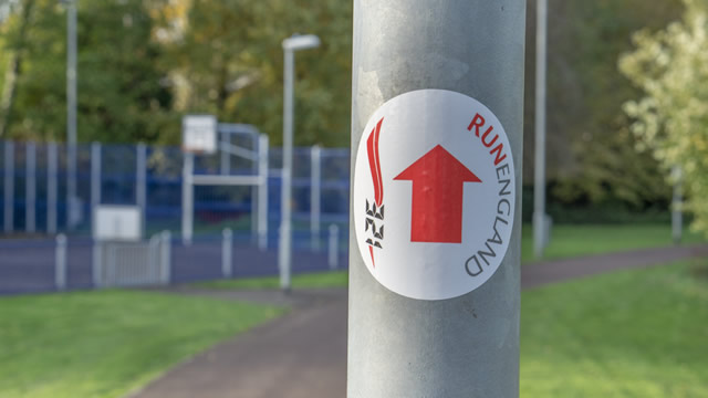 A directional sticker on a post near the Cale Park MUGA, at the turning point of the 1km route