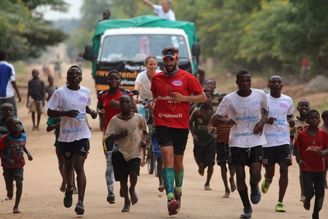 Brendan Rendall running in Malawi with local children