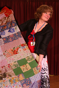 Linda displays a beautiful patchwork quilt for auction