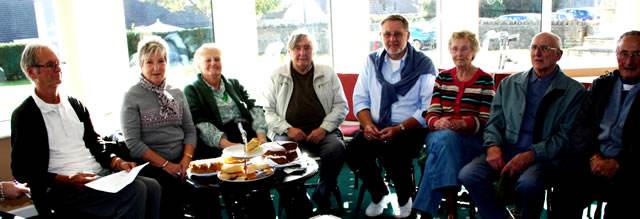Half the group sitting around cakes