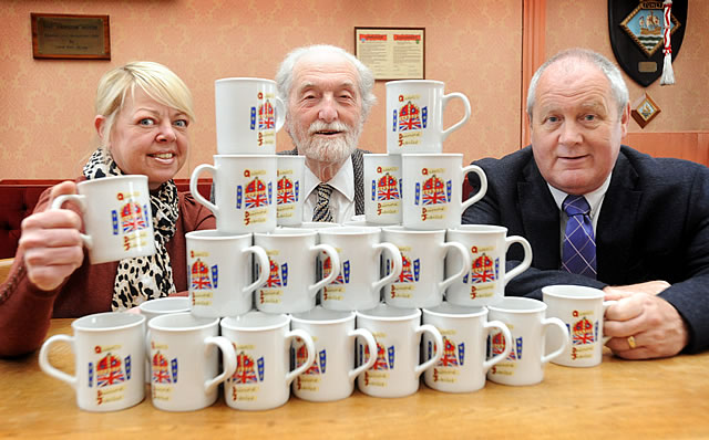 Town Clerk Sam Skirton and Councillors Colin Winder and Deryck Lemon, behind a stack of celebratory mugs