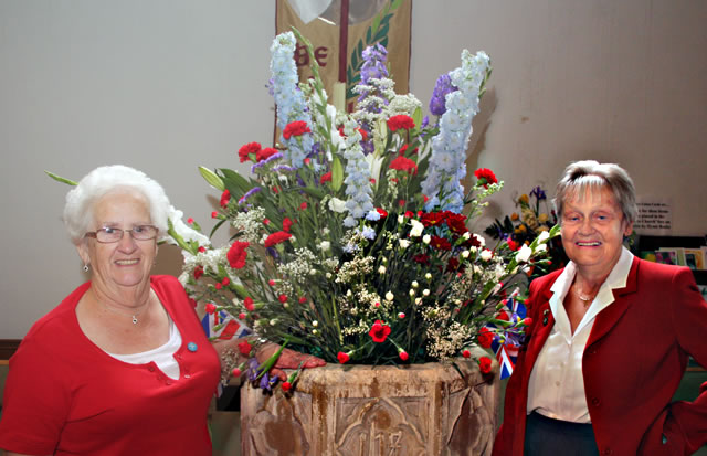 Church Wardens, Elizabeth Vivyan and Gill Oaten standing by Elizabeth's arrangement in the Font.