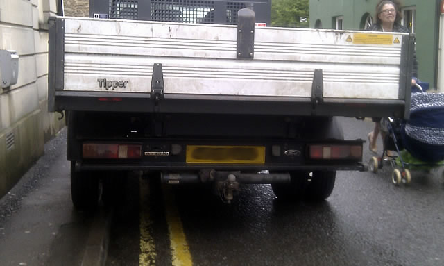 A mother forced to push a child in a pushchair around an illegally parked vehicle on South Street, Wincanton