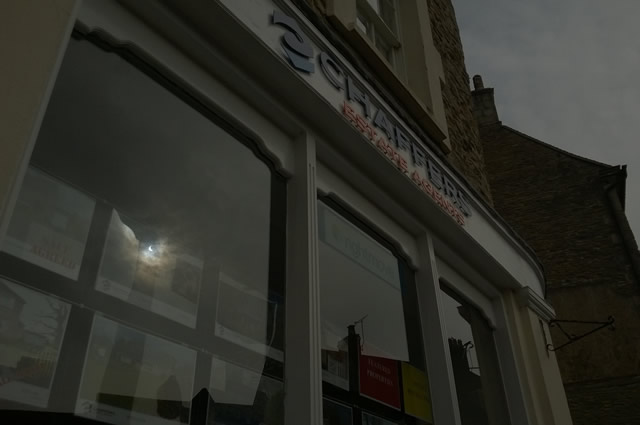The 2015 solar eclipse viewed in a reflection in Chaffers Estate Agents shop window, Market Place, Wincanton