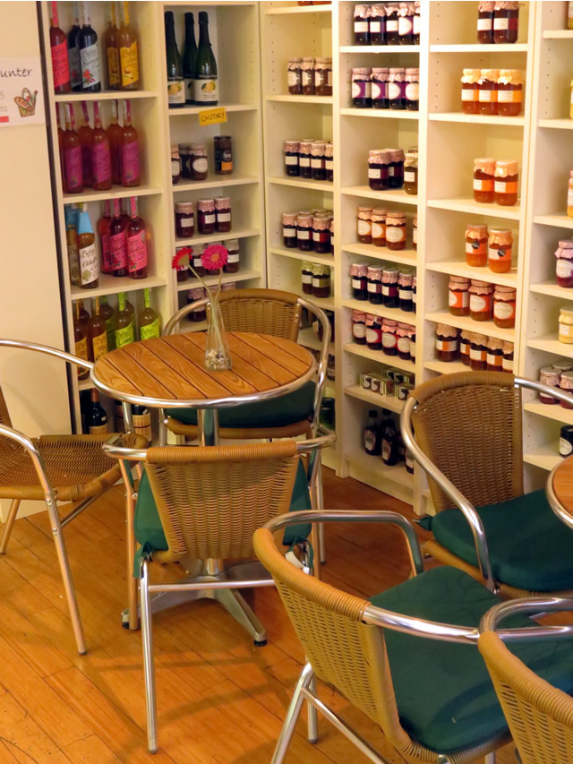 Space to sit, eat and chat at the Lemon Tree, in front of shelves of preserves