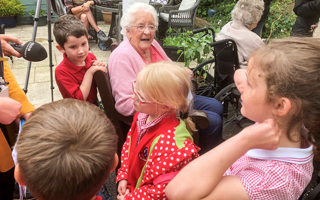 Pupils from Our Lady of Mount Carmel Primary School with residents of Carrington House, Wincanton, talking to BBC Somerset