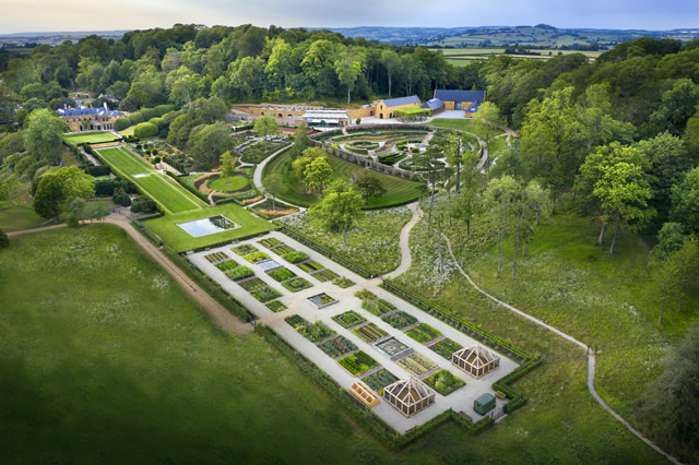 An aerial photo of The Newt in Somerset: looking northwards across the central gardens area, with the many new visitor buildings and cider press in the centre beyond the gardens, and the refurbished, extended and converted Grade II* Hadspen House to the left