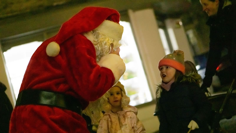 Young children placing orders with Santa after Wincanton's Christmas lantern parade 2021