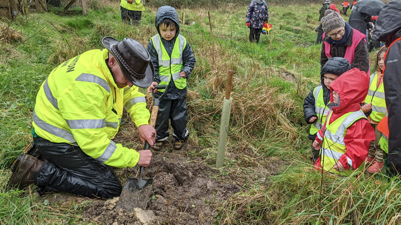 Children from Conkers Nursery planting an oak sapling with the help of Steve Lee, Wincanton Town Council Works and Maintenance Supervisor