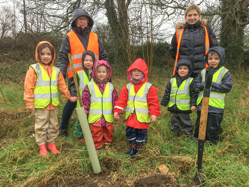 Children from Conkers Nursery planting an aptly chosen horse chestnut sapling